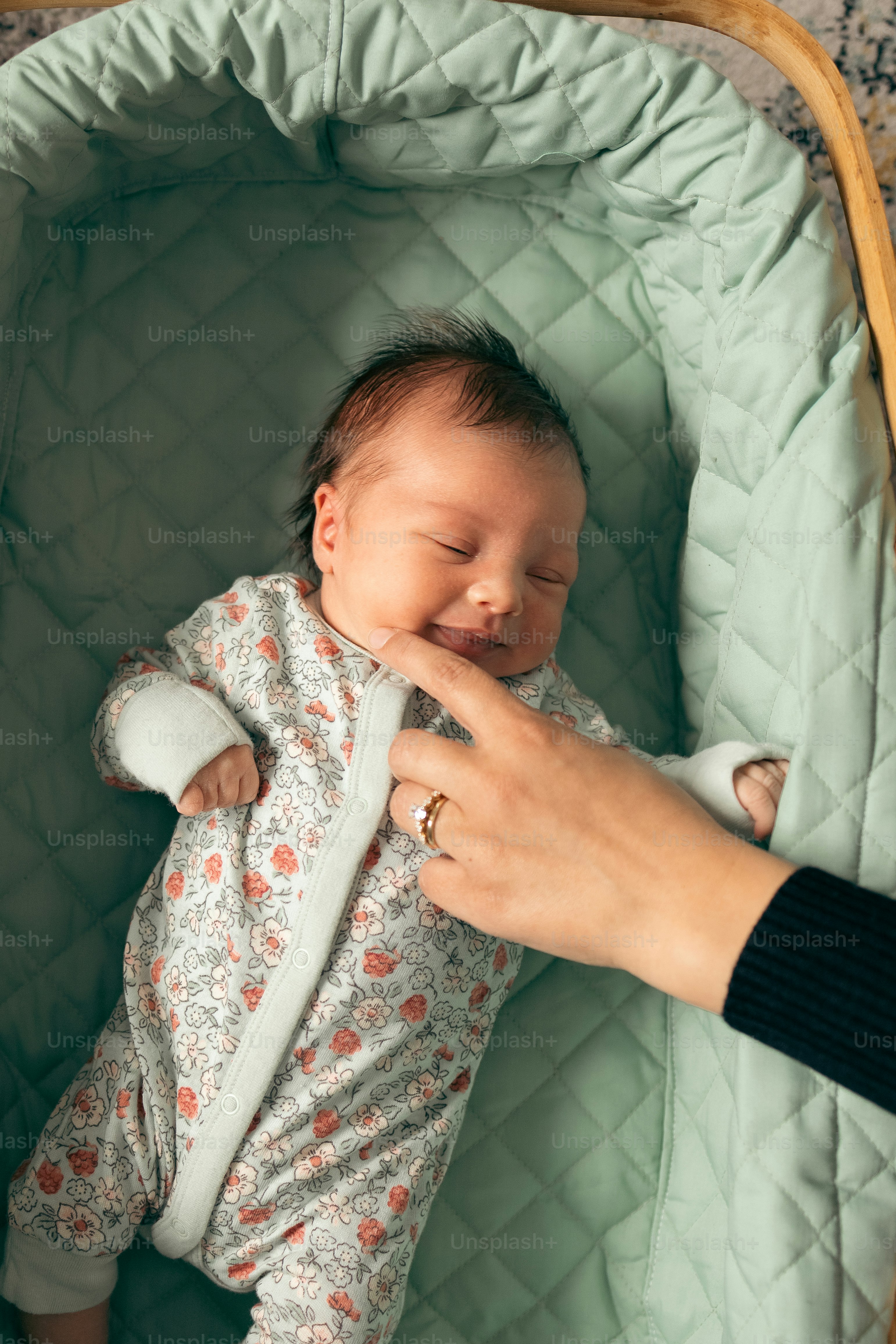 un bébé dort dans une couverture verte