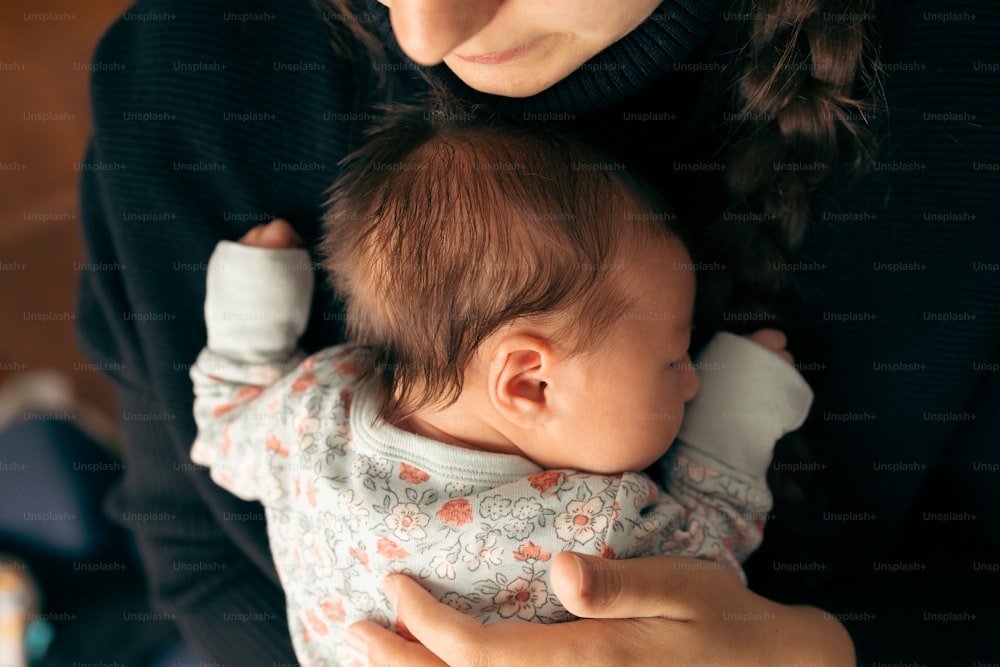 Una mujer sosteniendo a un bebé en sus brazos