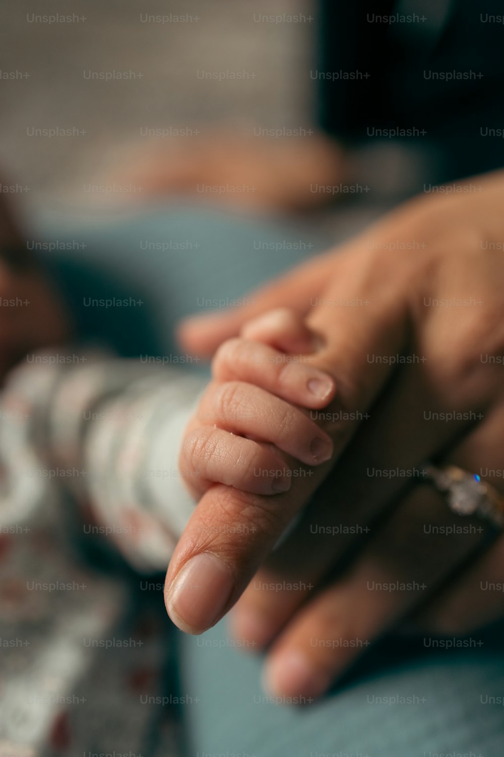 Un primer plano de una persona sosteniendo la mano de un bebé