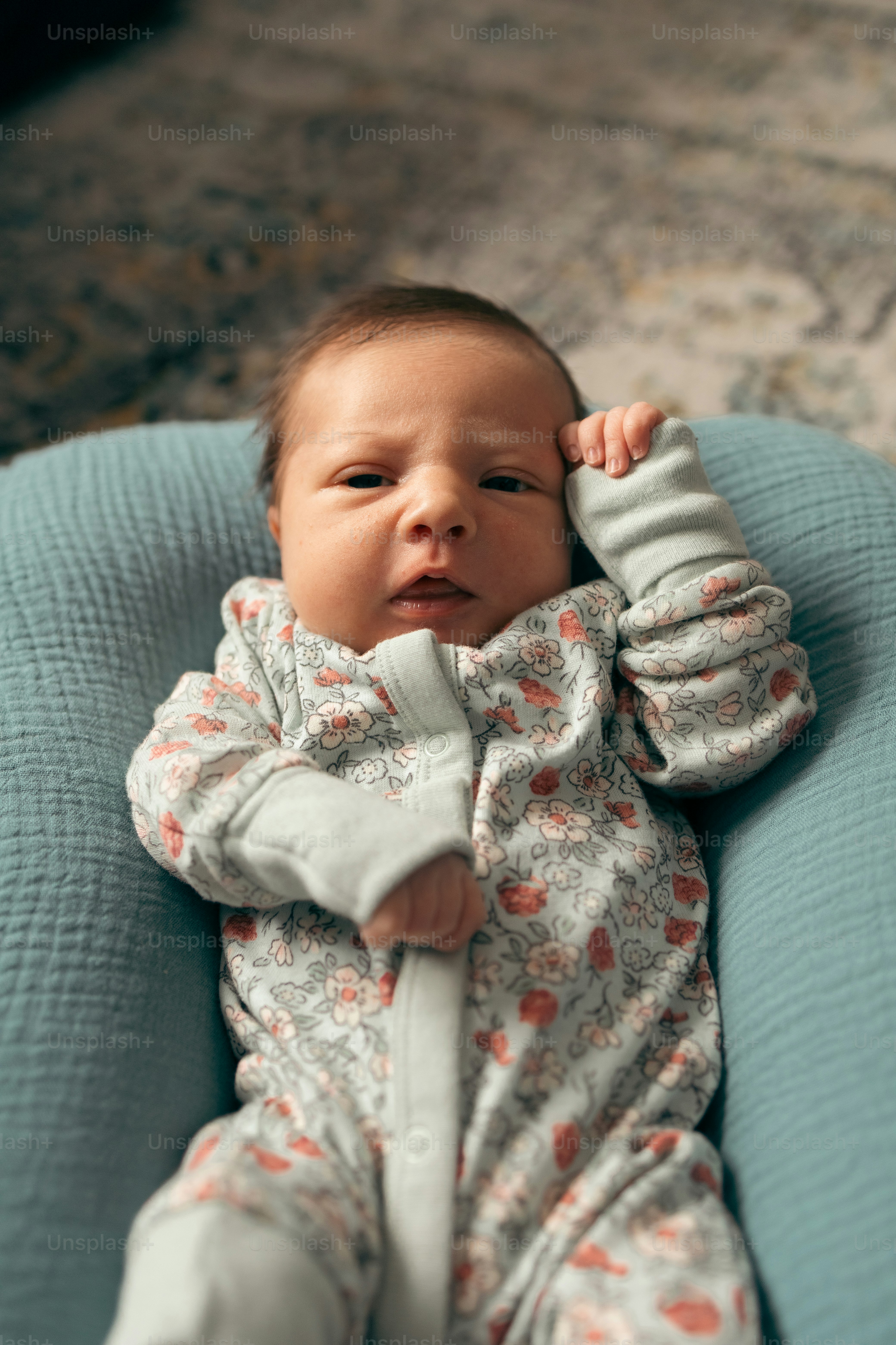 赤ちゃんが青い椅子に横たわっている