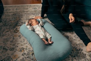 Un bebé acostado en una silla de bolsa de frijoles azules