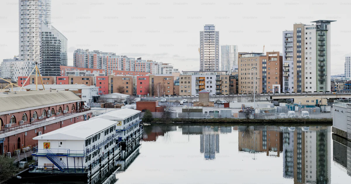 Splashed Buildings A body of water surrounded by tall buildings photo – London Image on ...