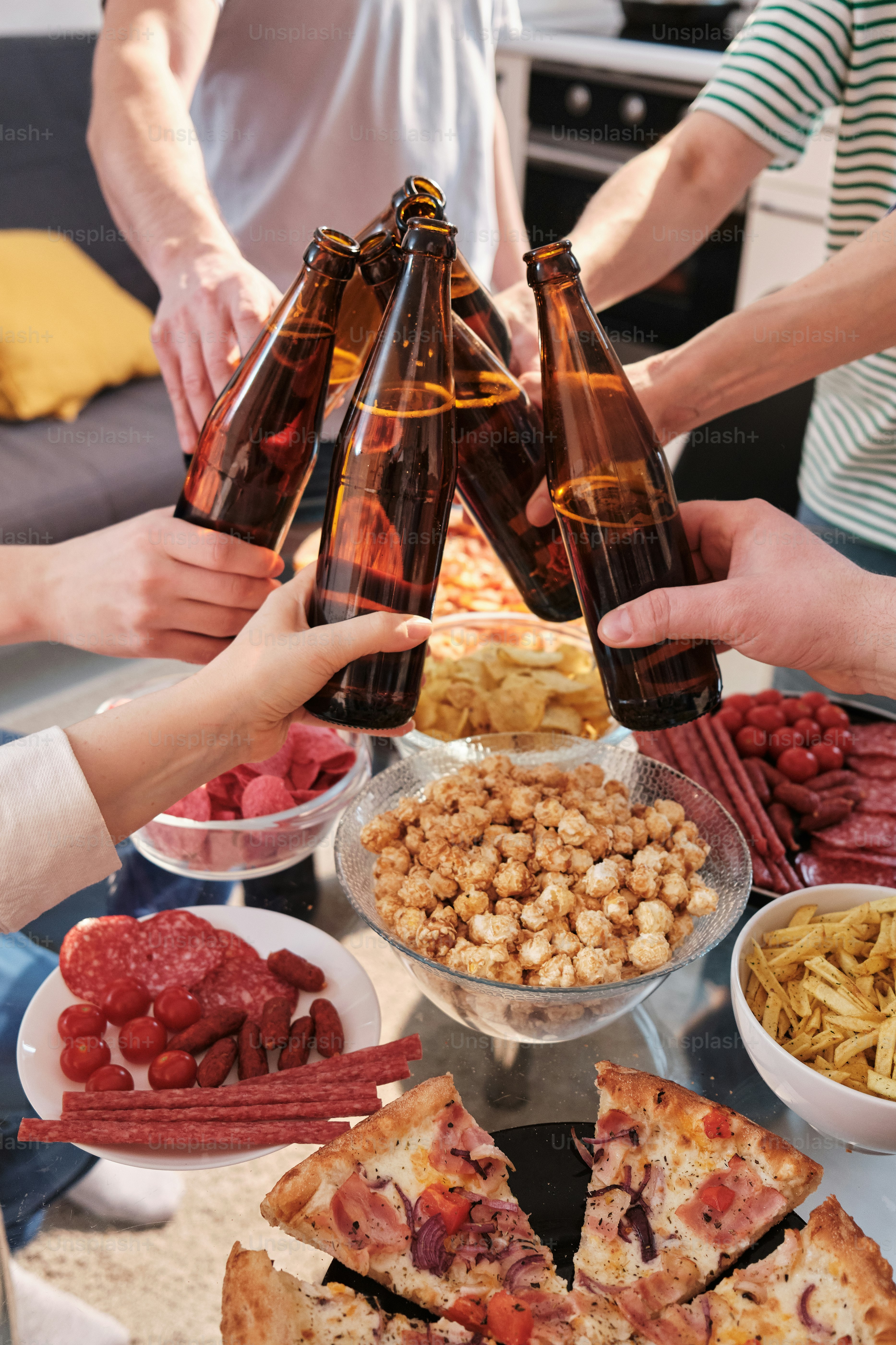 a group of people standing around a table filled with food
