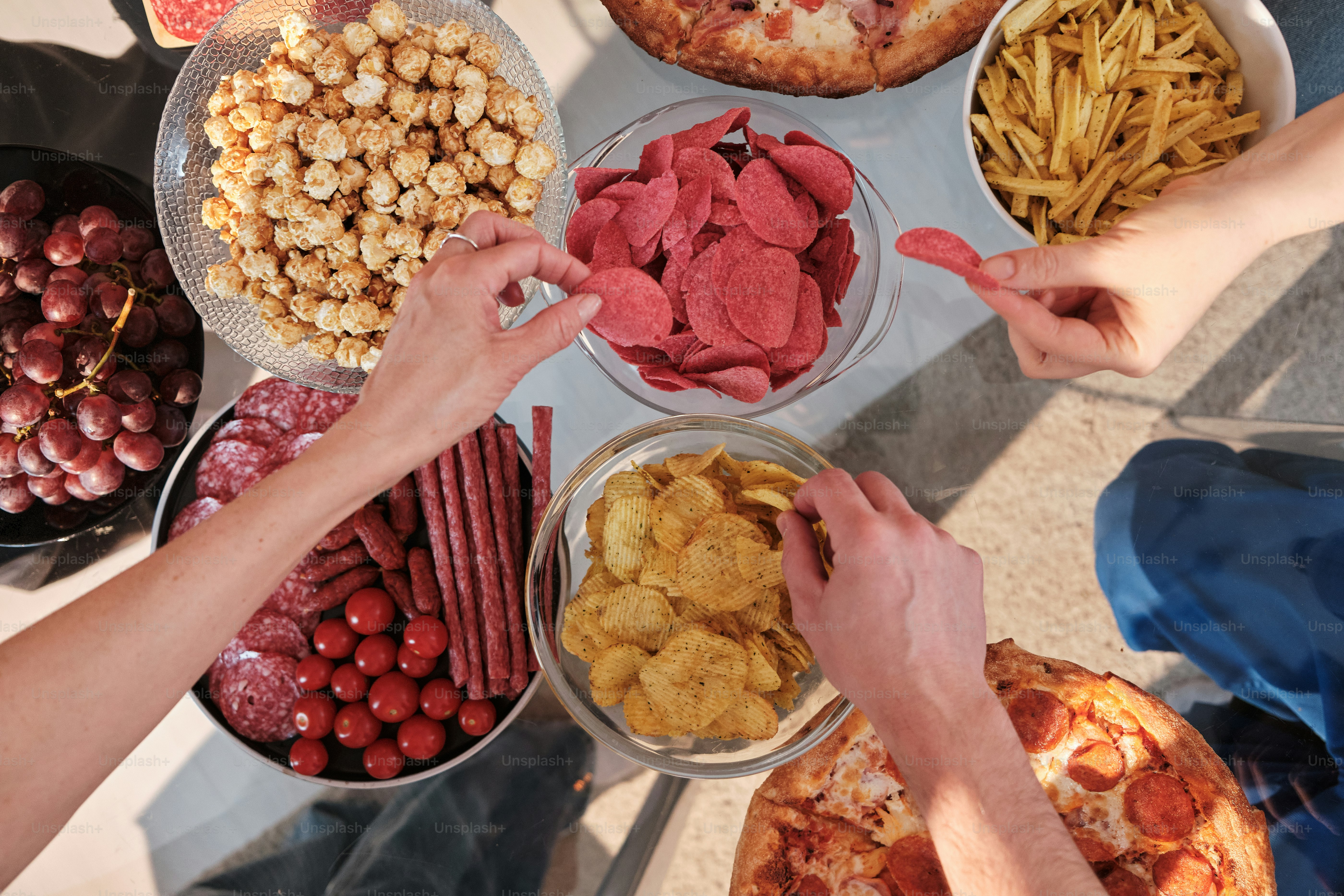 un gruppo di persone in piedi intorno a un tavolo pieno di cibo
