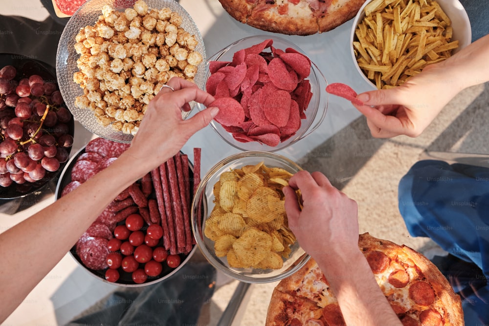 a group of people standing around a table filled with food