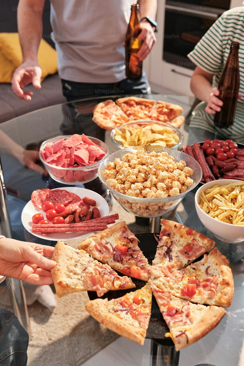 a group of people standing around a table full of food
