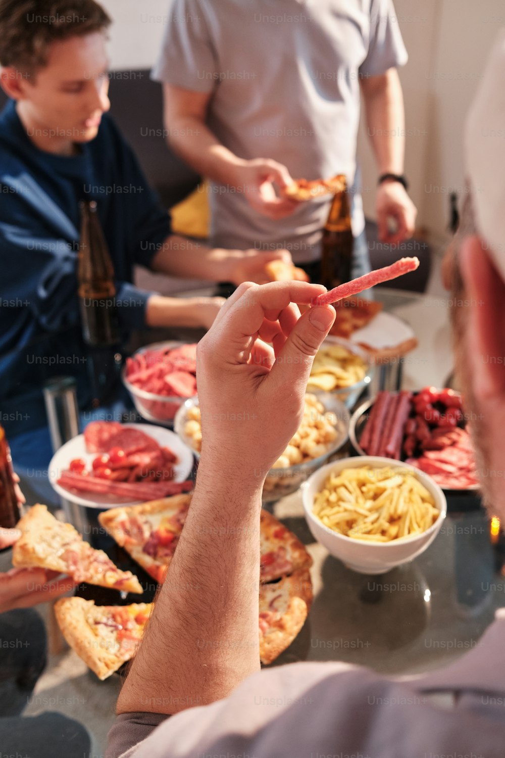 a group of people standing around a table filled with food