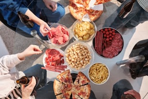 un groupe de personnes debout autour d’une table remplie de nourriture