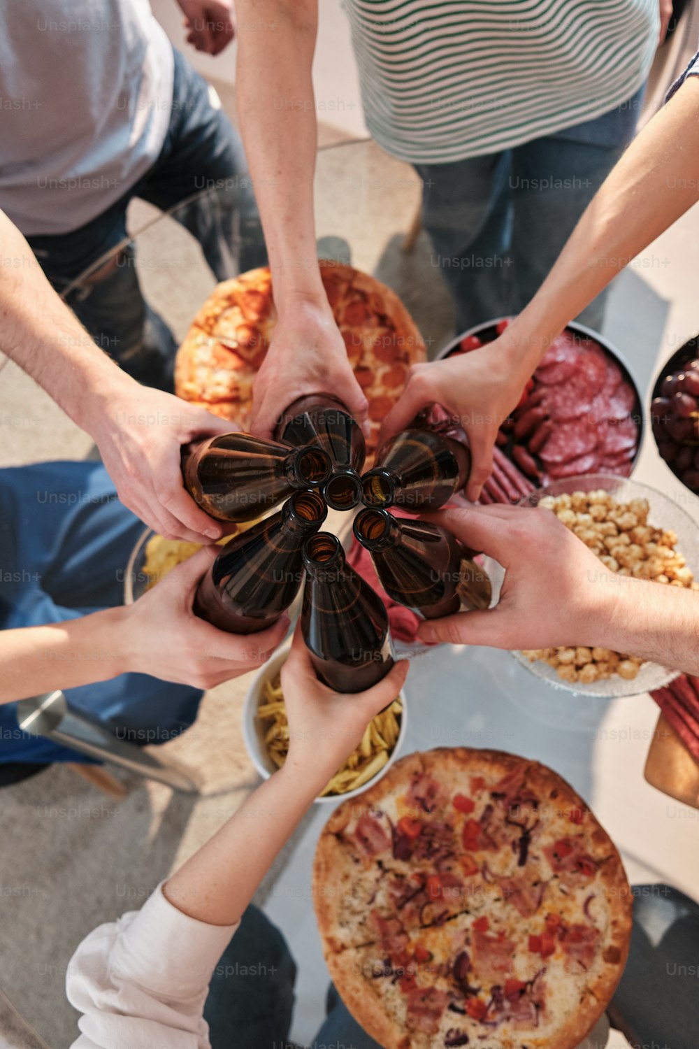 a group of people holding hands over a table full of food