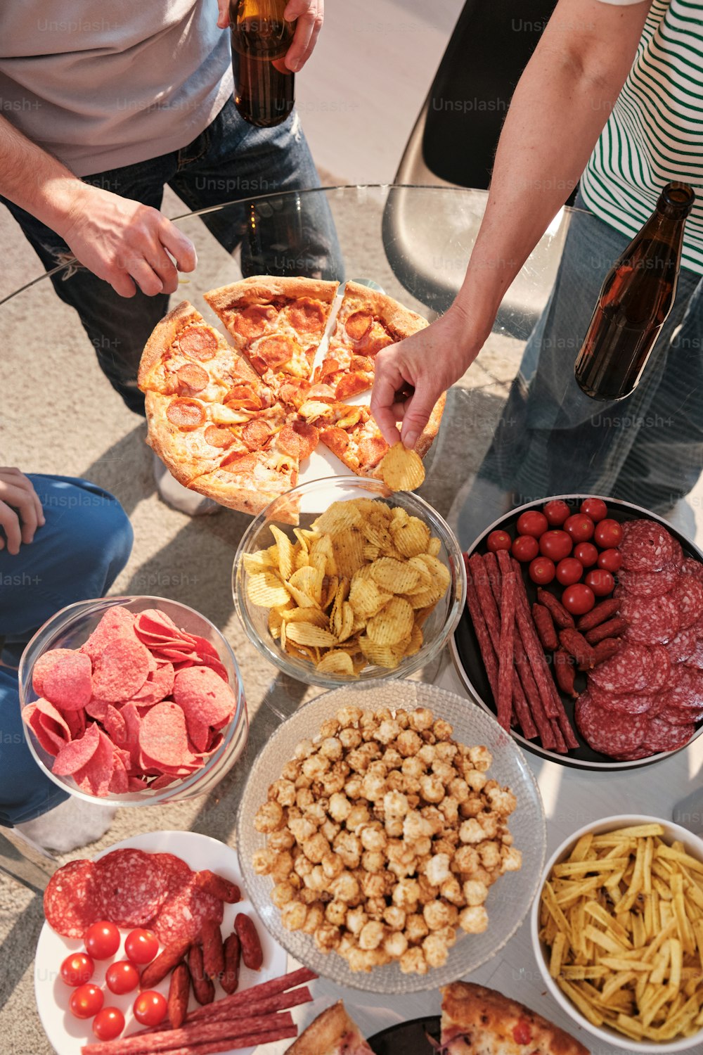 a group of people standing around a table full of food