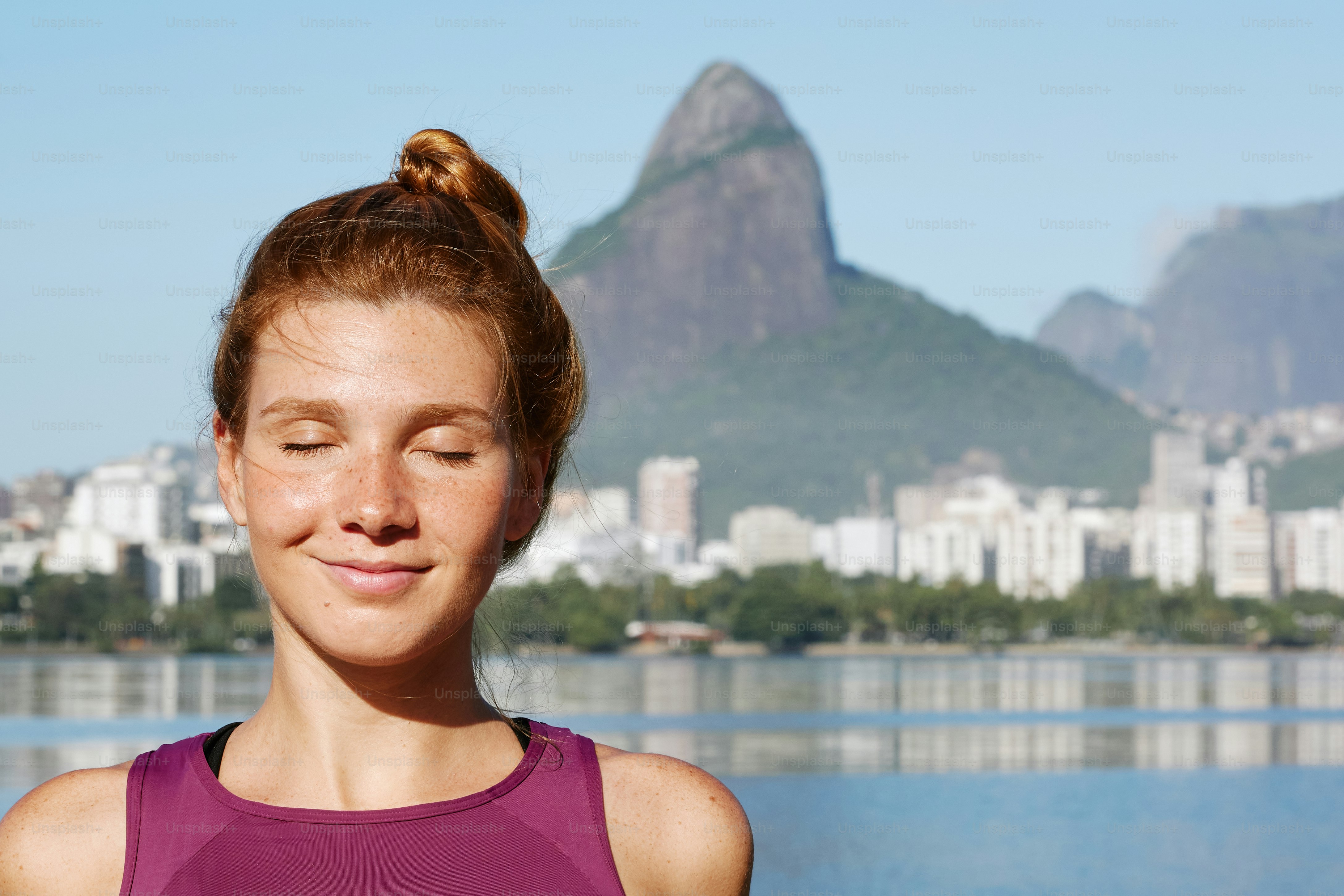 a woman standing in front of a body of water