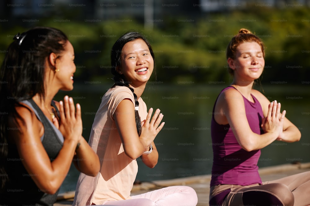 a group of women sitting on the ground doing yoga