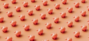 Un grande gruppo di salvadanai rosa su uno sfondo arancione