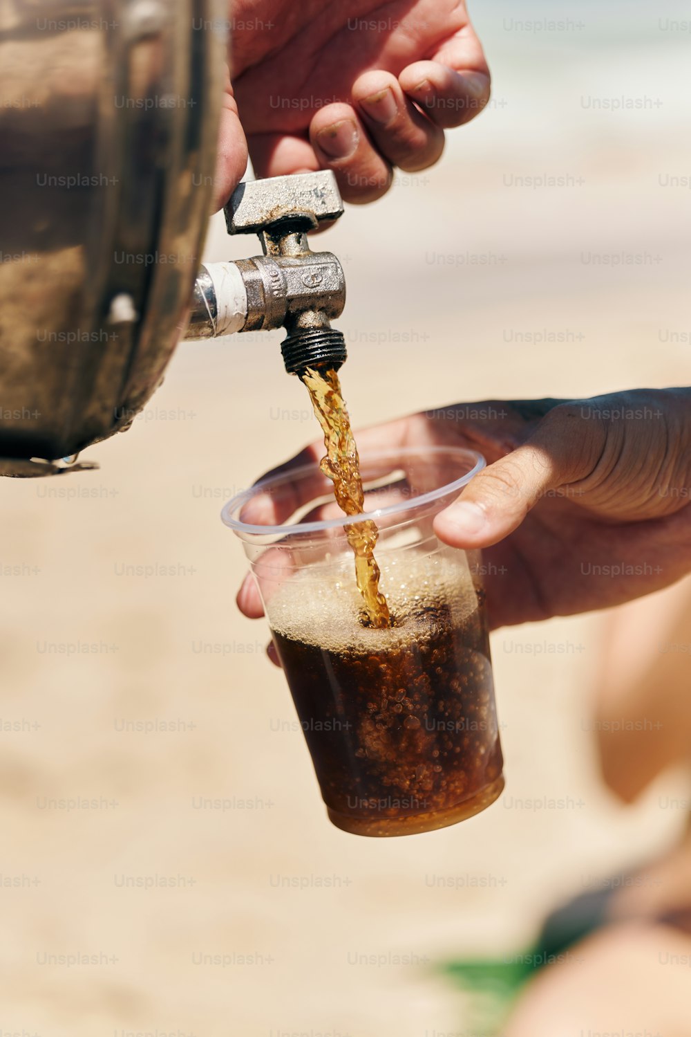 a person is pouring a drink into a glass