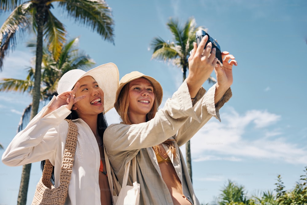 duas mulheres tirando uma foto com um telefone celular