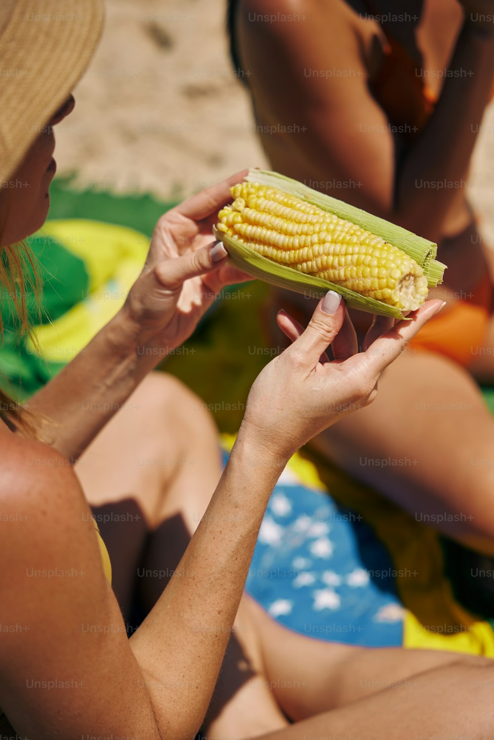 a woman is holding a corn on the cob