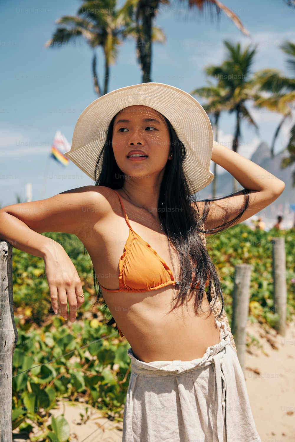 Una mujer en bikini y sombrero en una playa