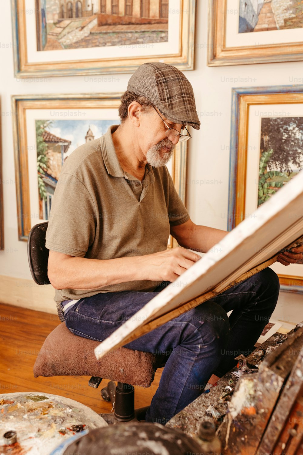 a man sitting on a stool working on a piece of art
