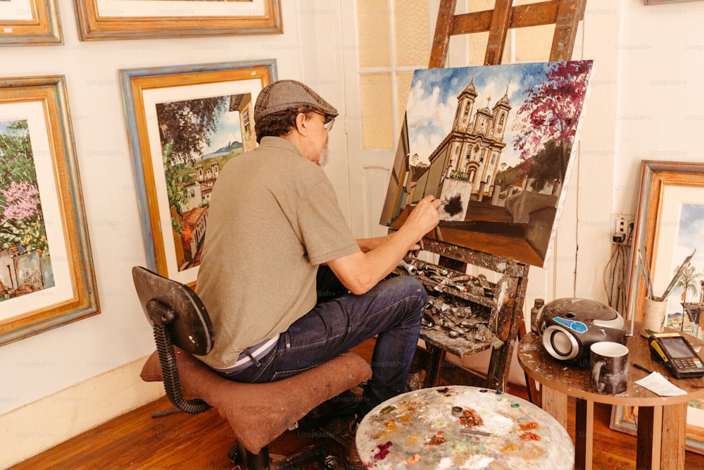 Un uomo seduto su una sedia di fronte a un dipinto