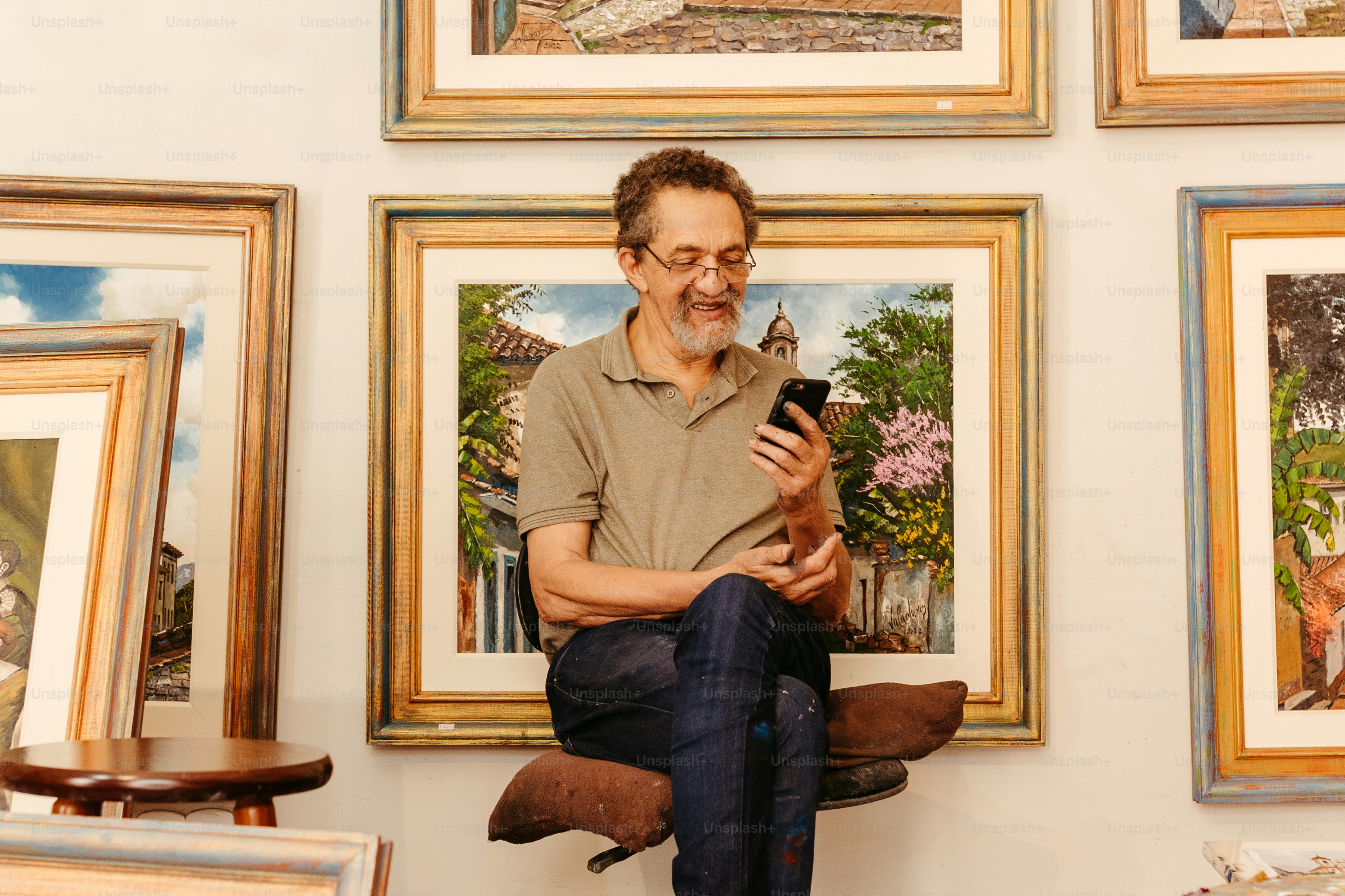 a man sitting on a chair looking at a cell phone