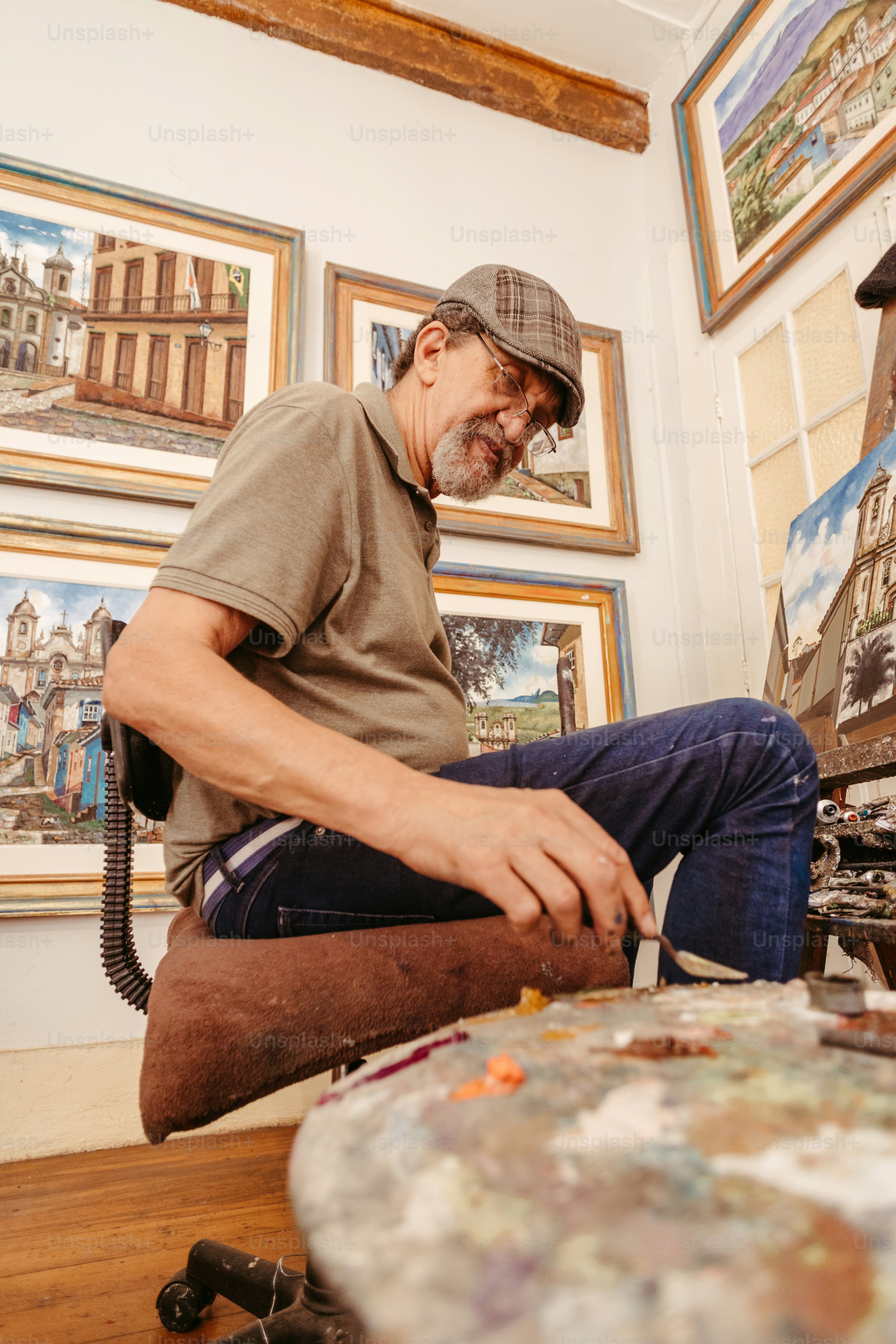 a man sitting on the floor working on a piece of art