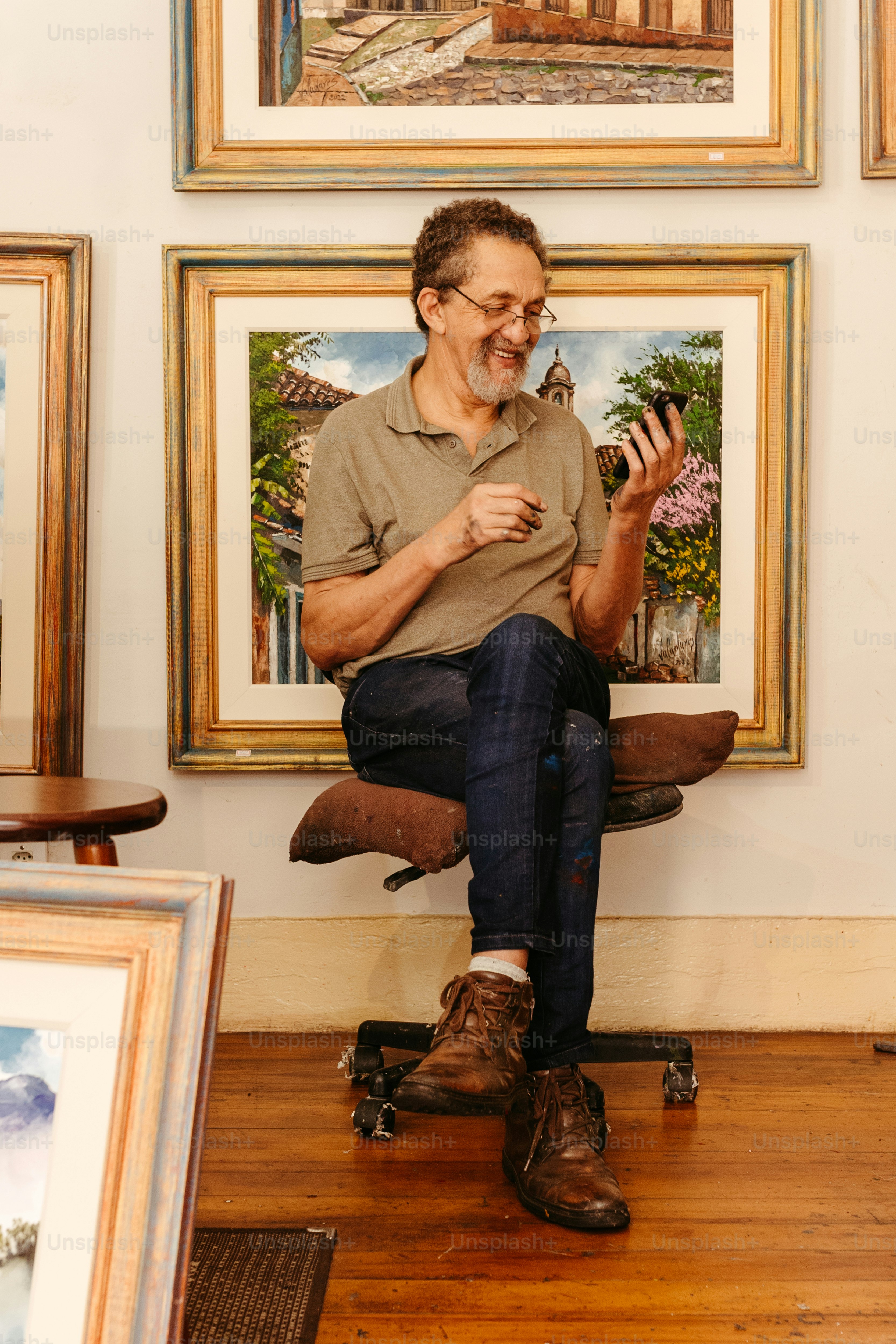 a man sitting on top of a skateboard in front of paintings
