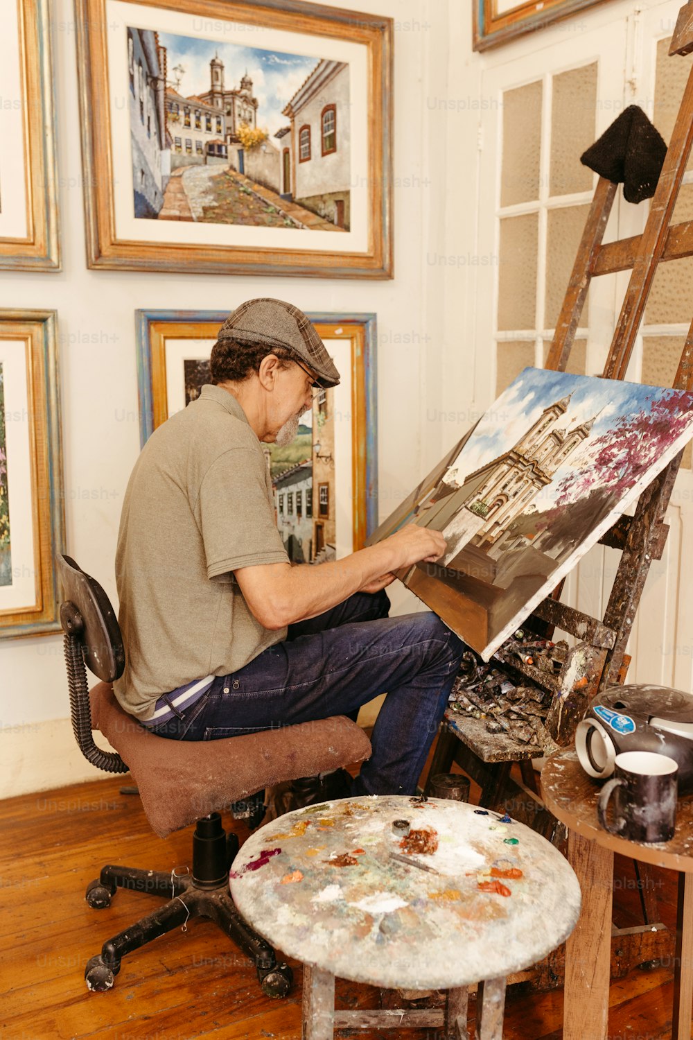 a man sitting on a chair in front of a painting