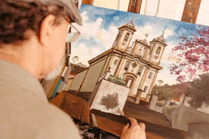 Un hombre está pintando un cuadro de una iglesia