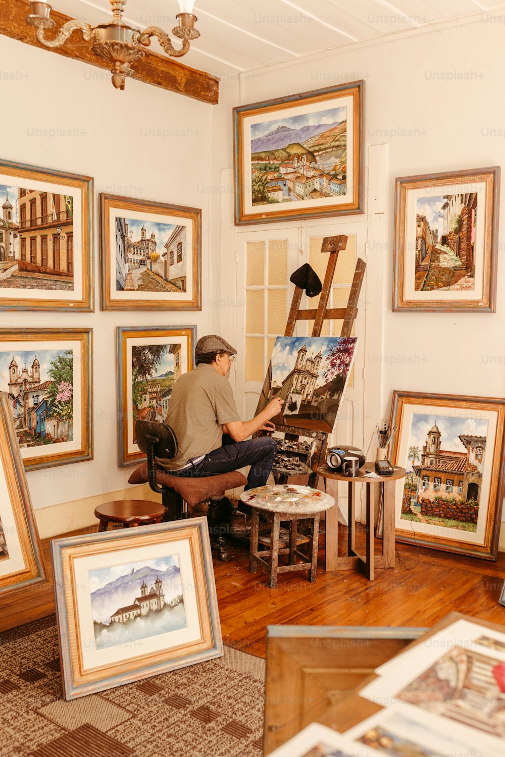 um homem sentado em uma cadeira na frente de pinturas