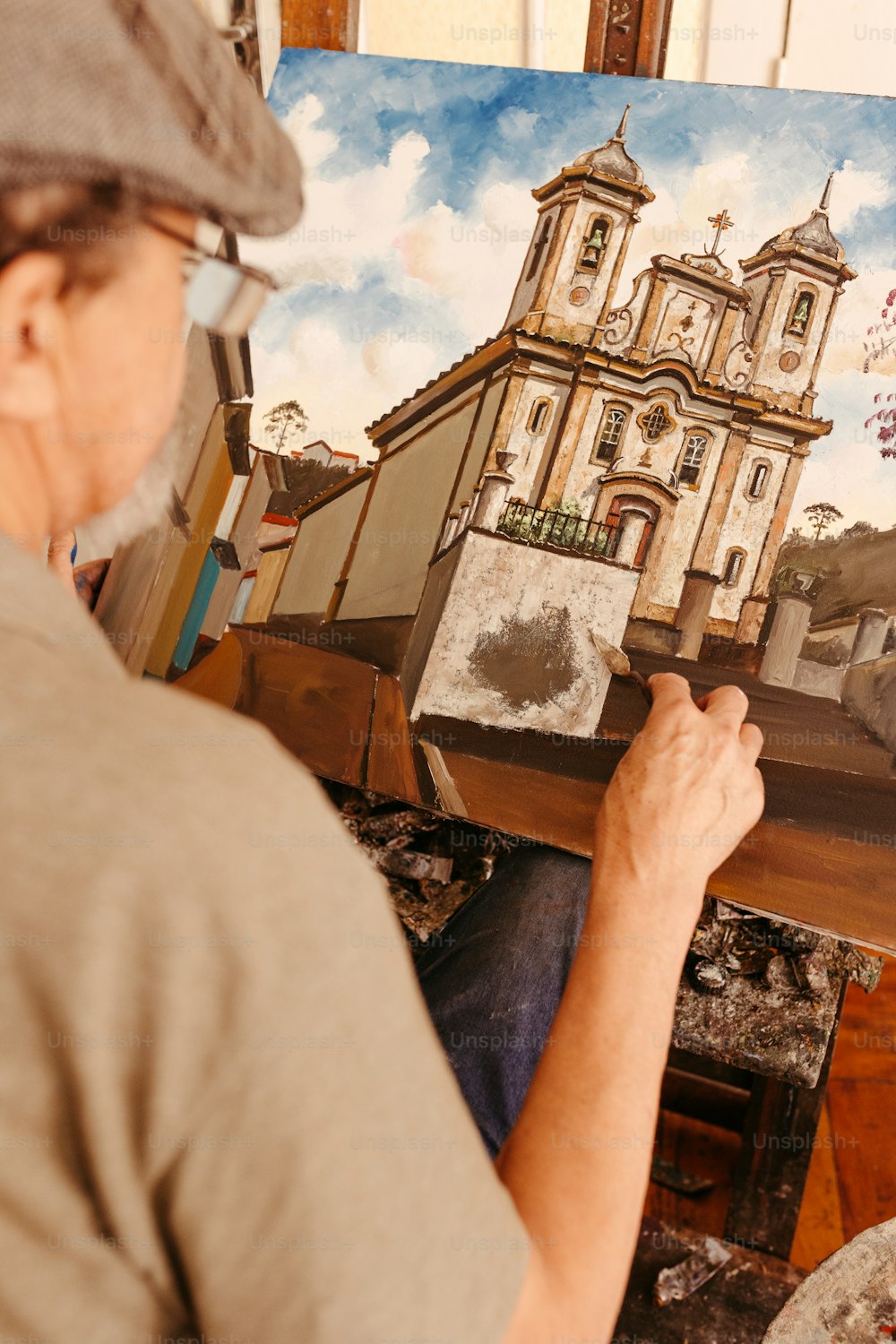 Un hombre está pintando un cuadro de una iglesia