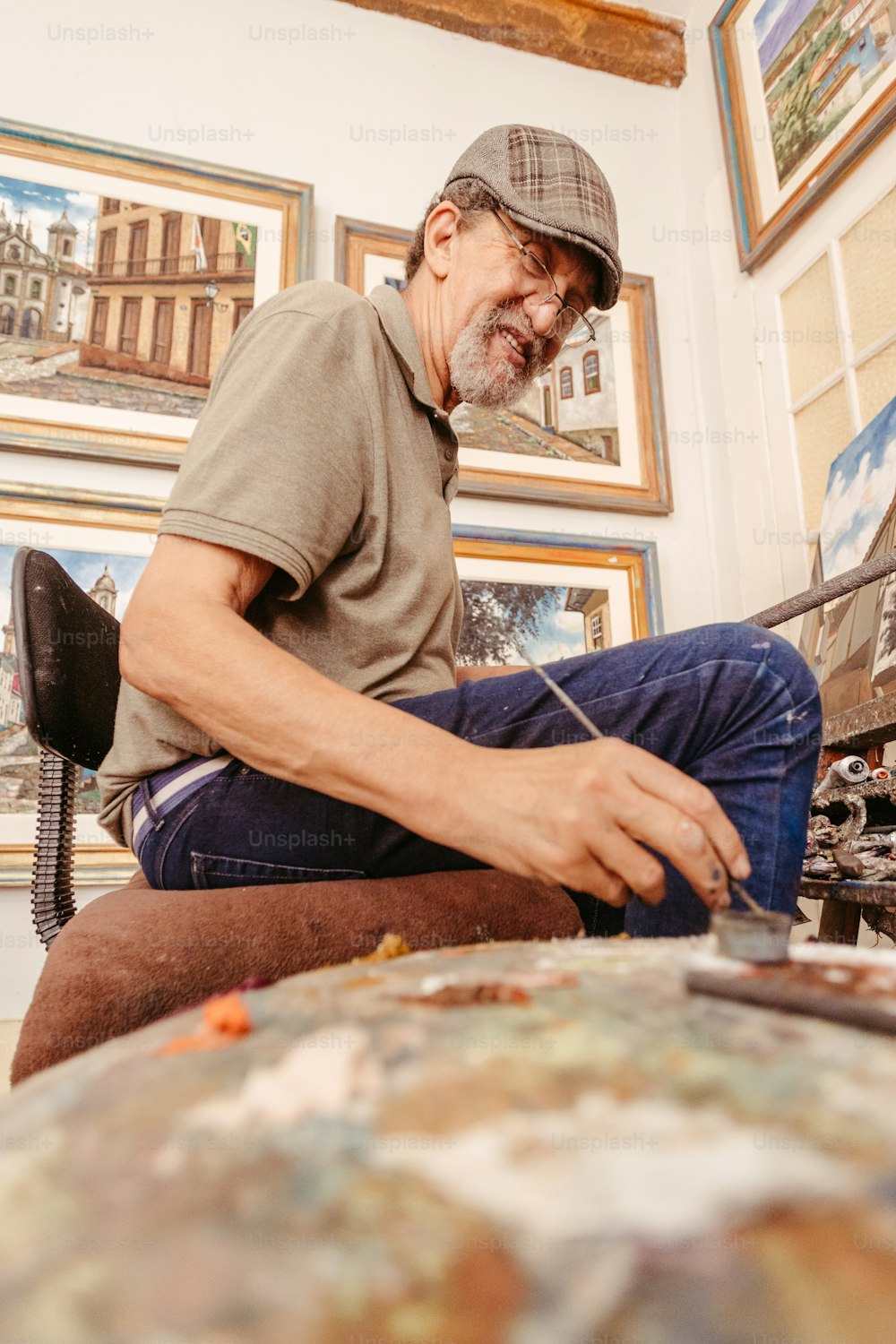 a man sitting on a chair working on a piece of art