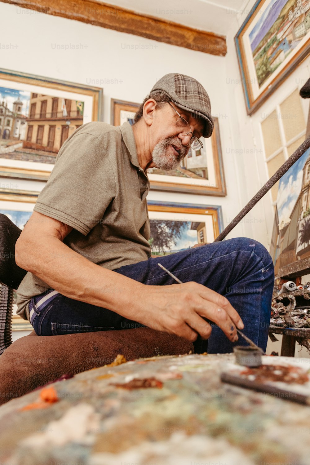 a man sitting in front of a painting on a easel