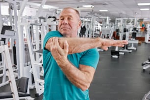 a man in a gym with his arms stretched out