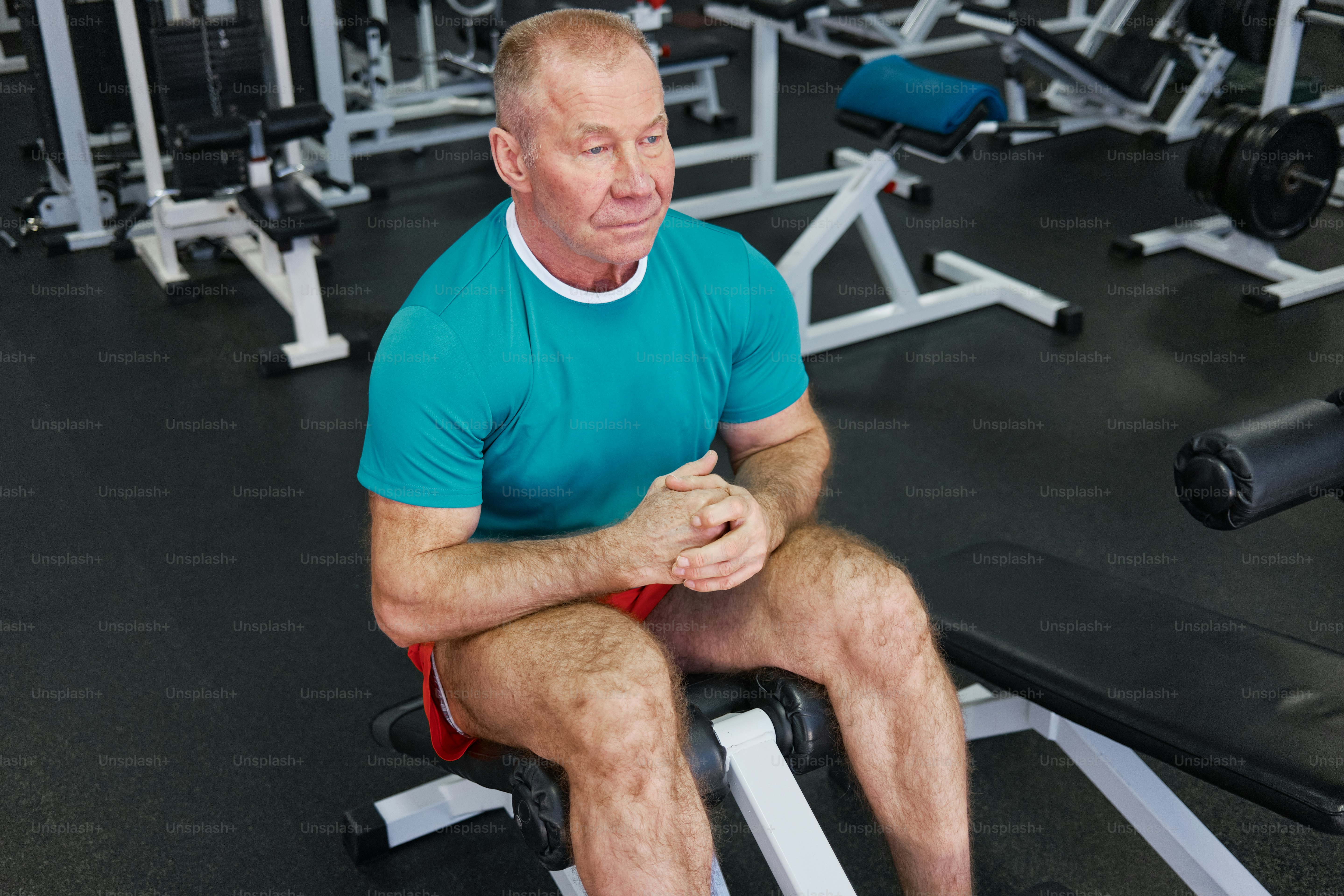 a man sitting on a bench in a gym
