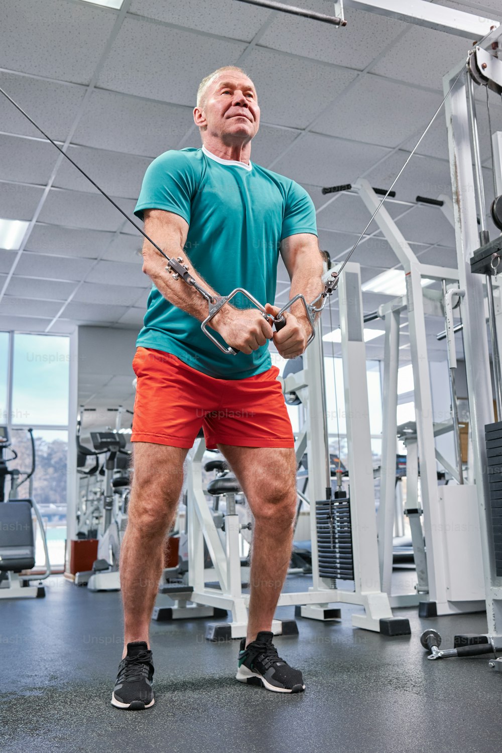 a man in a gym holding a rope