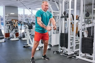 a man in a gym holding a rope