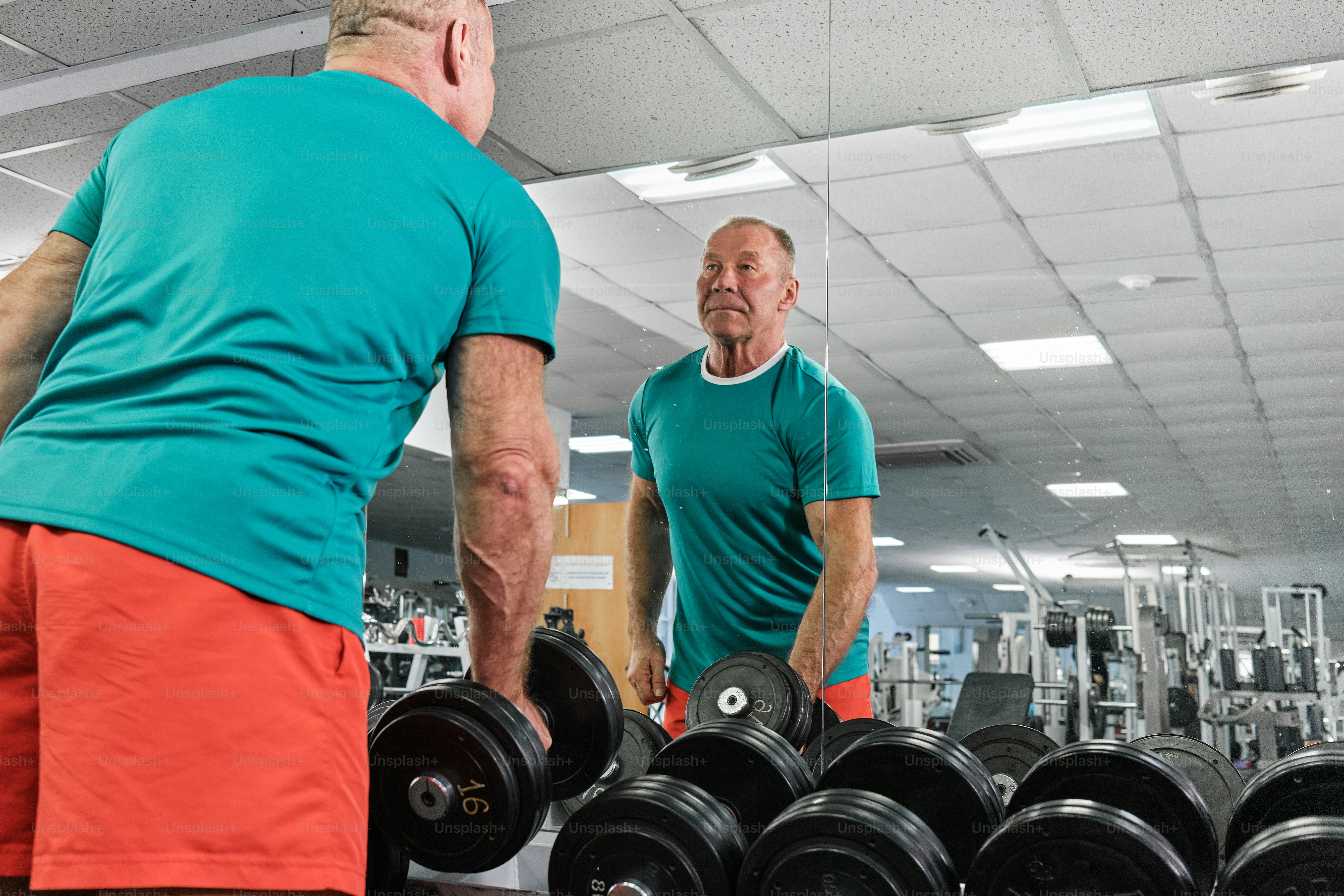 a couple of men standing next to each other in a gym