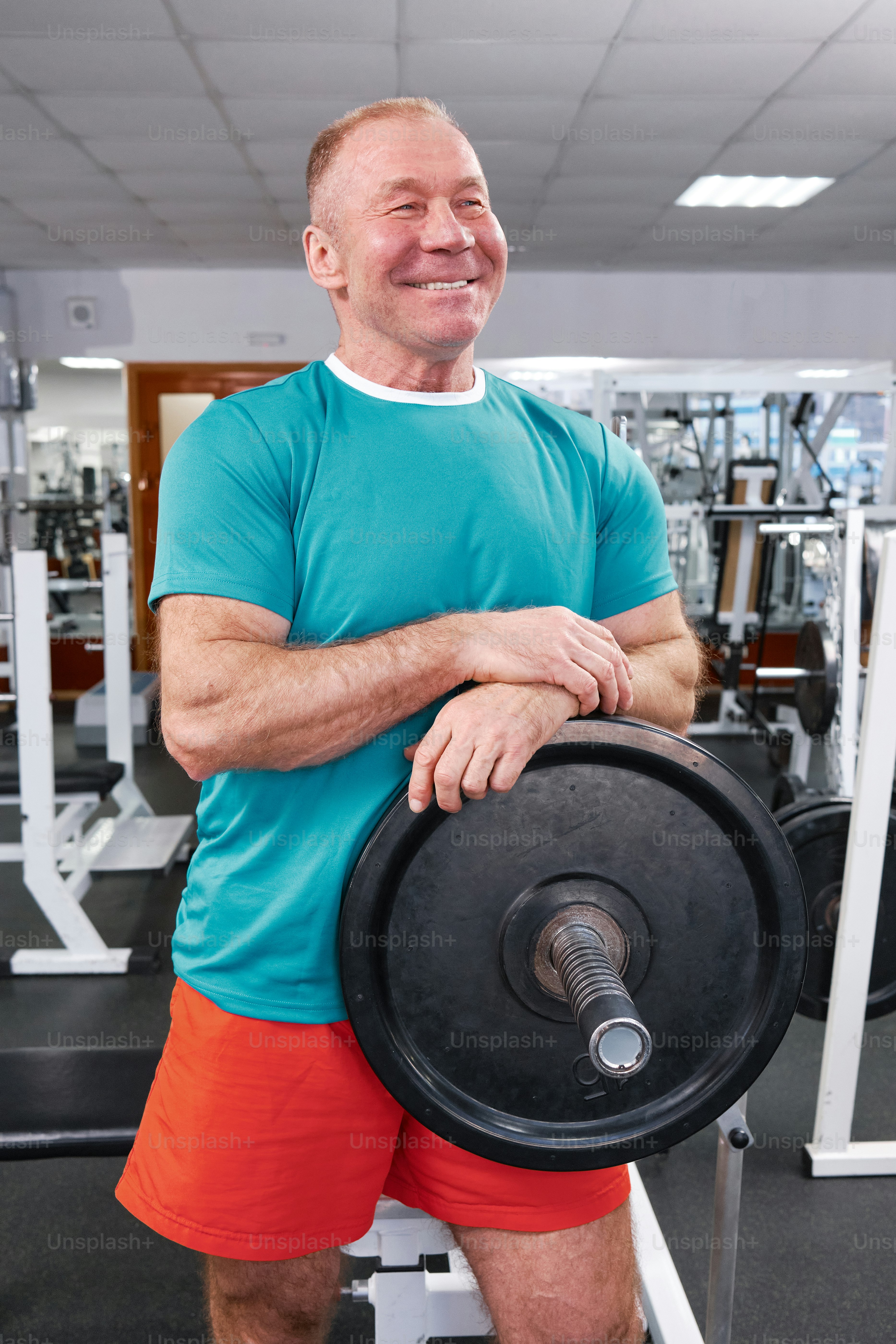 a man holding a barbell in a gym