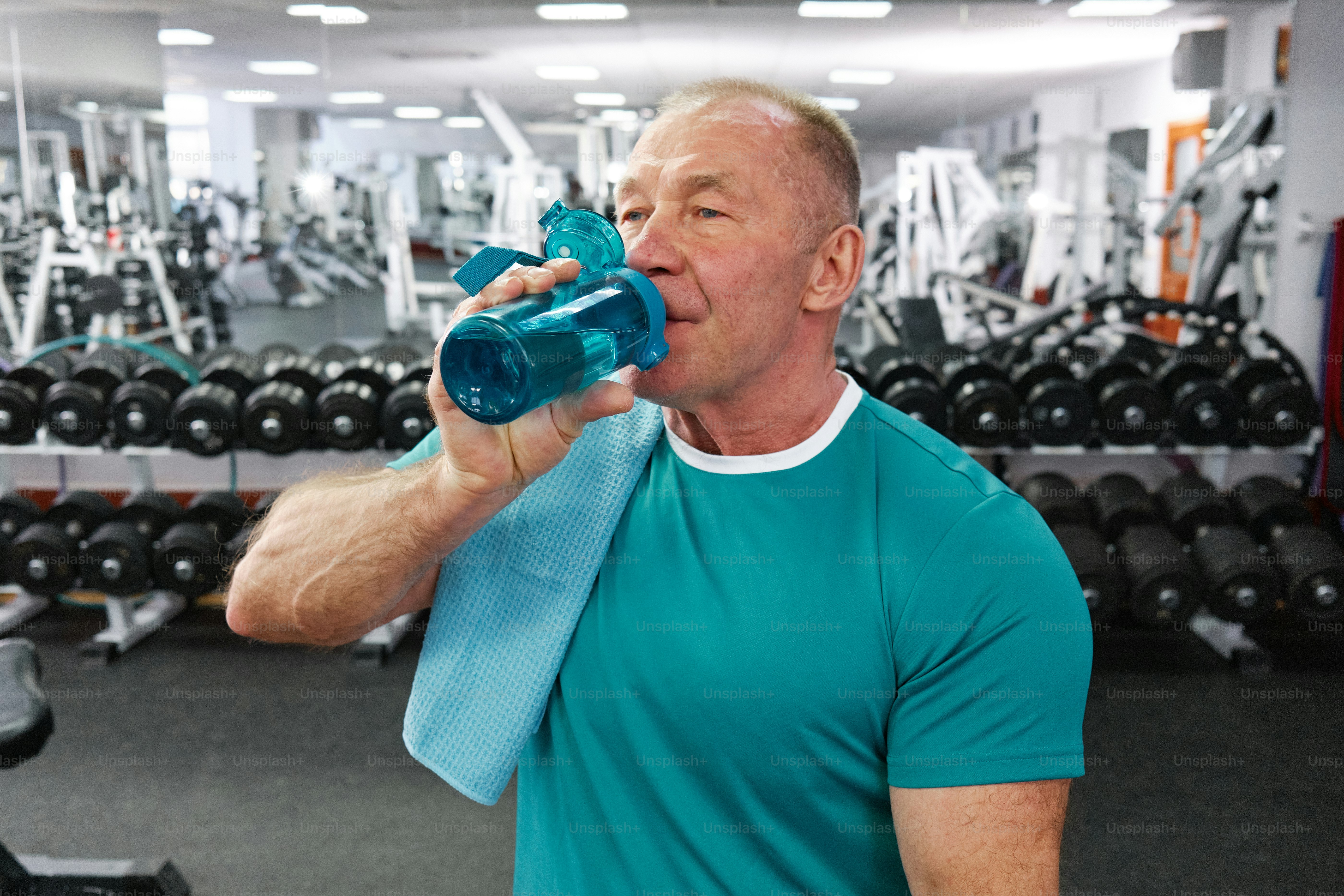 A man in a gym drinking from a water bottle photo – Gym Image on Unsplash