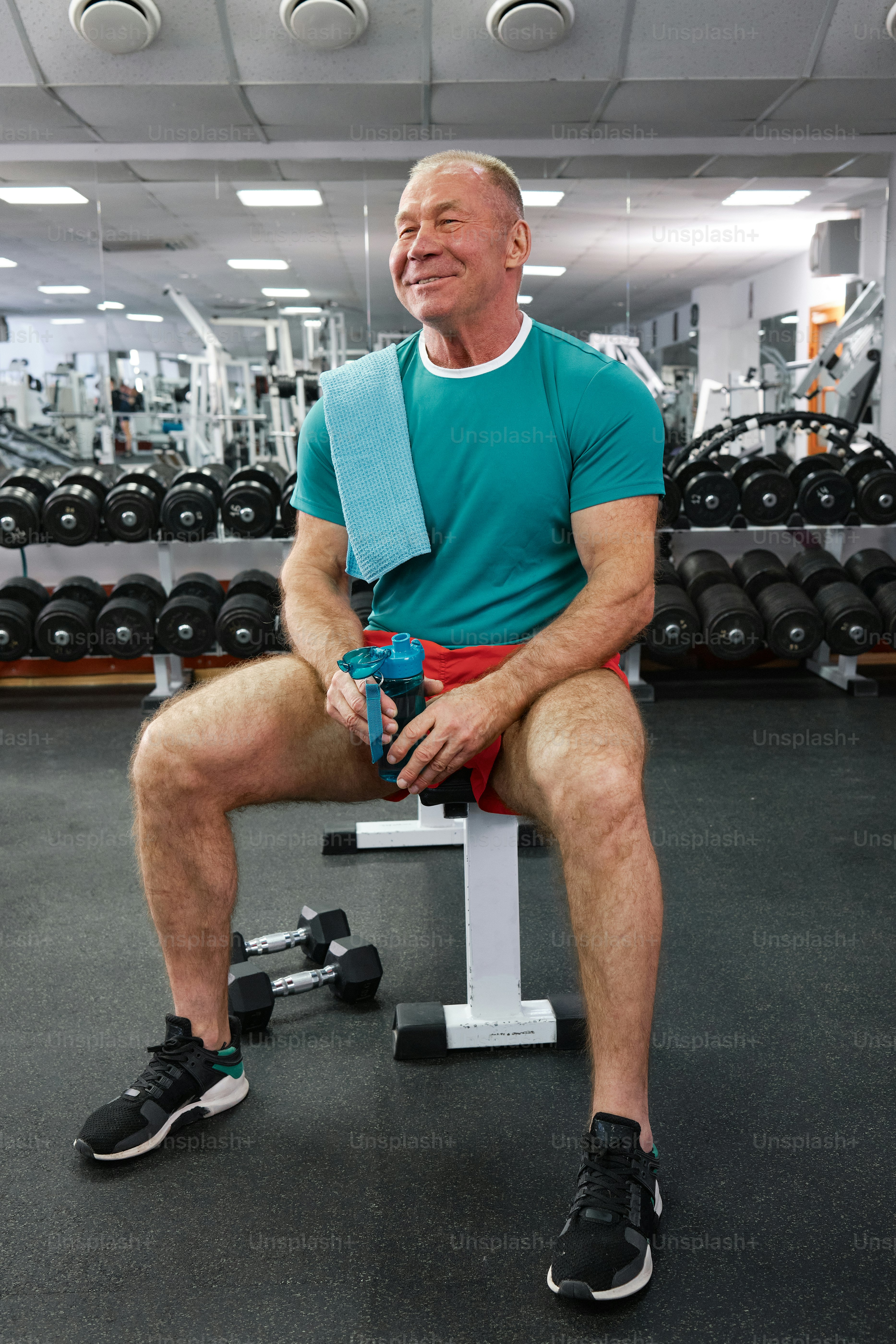 a man sitting on a bench in a gym