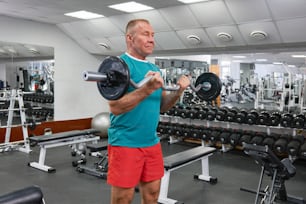 a man lifting a barbell in a gym