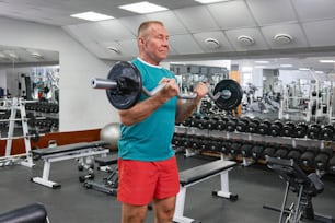 Un hombre levantando una barra en un gimnasio