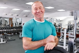 a man standing in a gym with his arms crossed