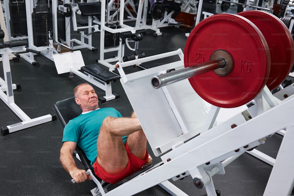 a man laying on a bench in a gym