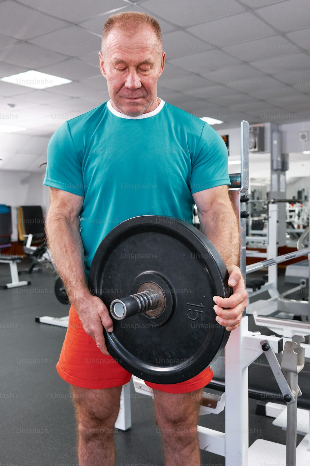 a man holding a large black disc in a gym