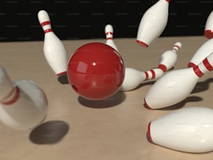 a group of white and red bowling pins and a red ball