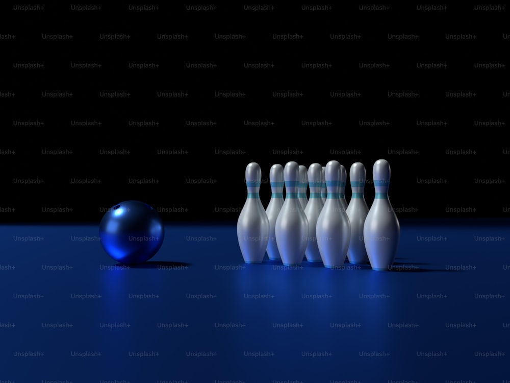 a group of bowling pins sitting next to a blue ball