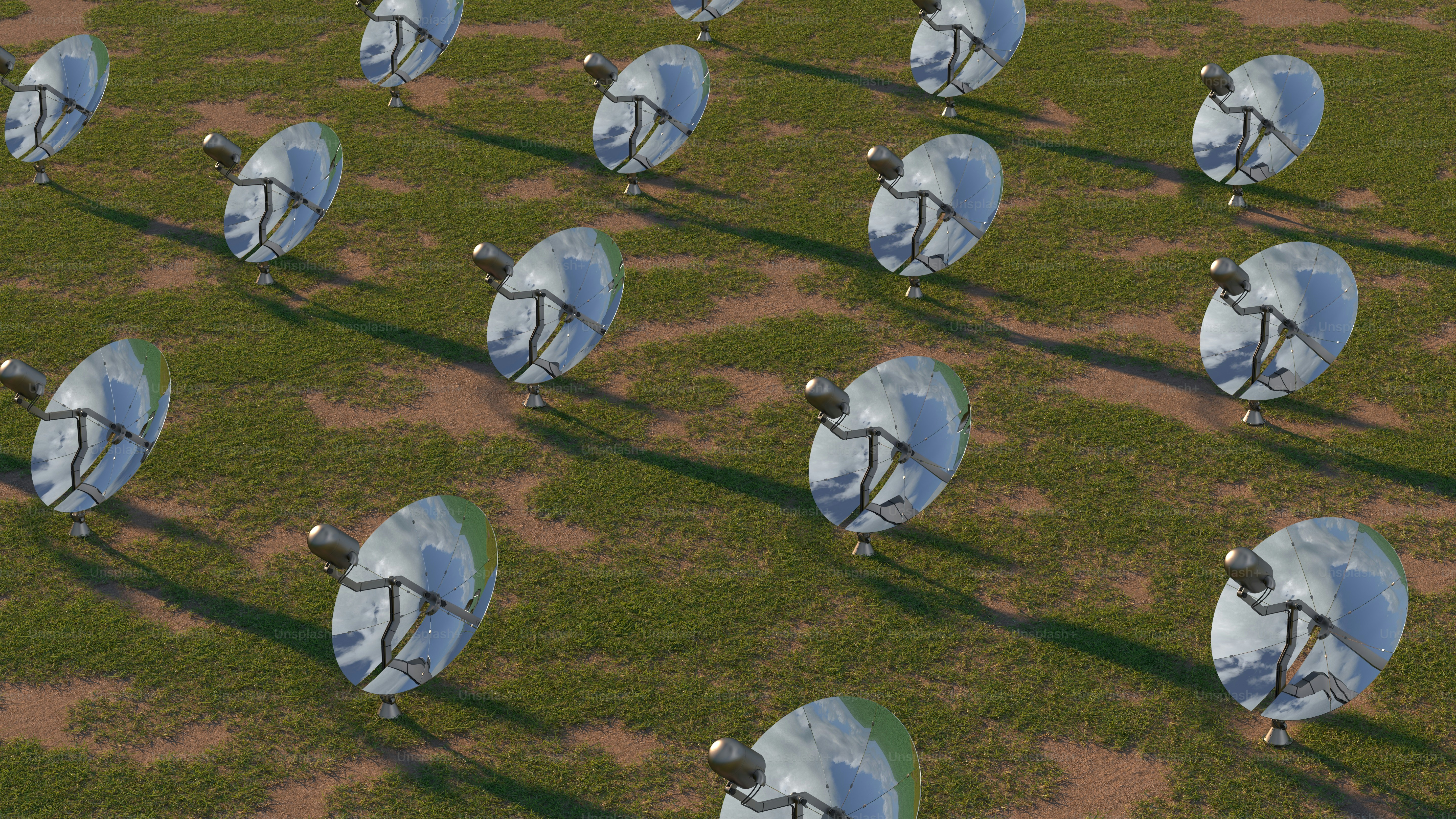 Un gruppo di antenne paraboliche sedute in cima a un campo coperto di erba