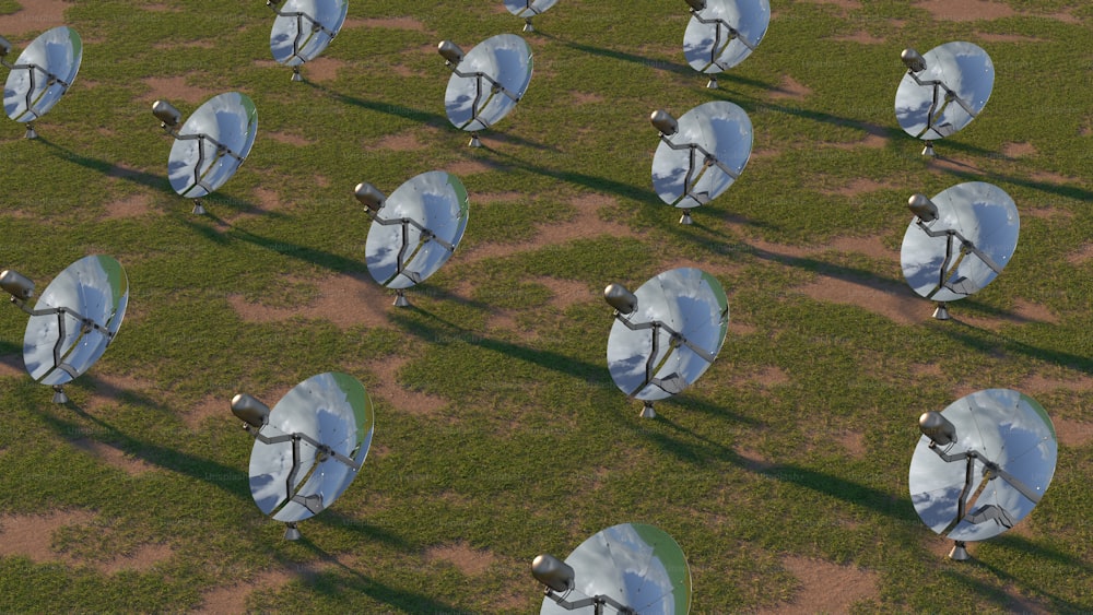 a group of satellite dishes sitting on top of a grass covered field