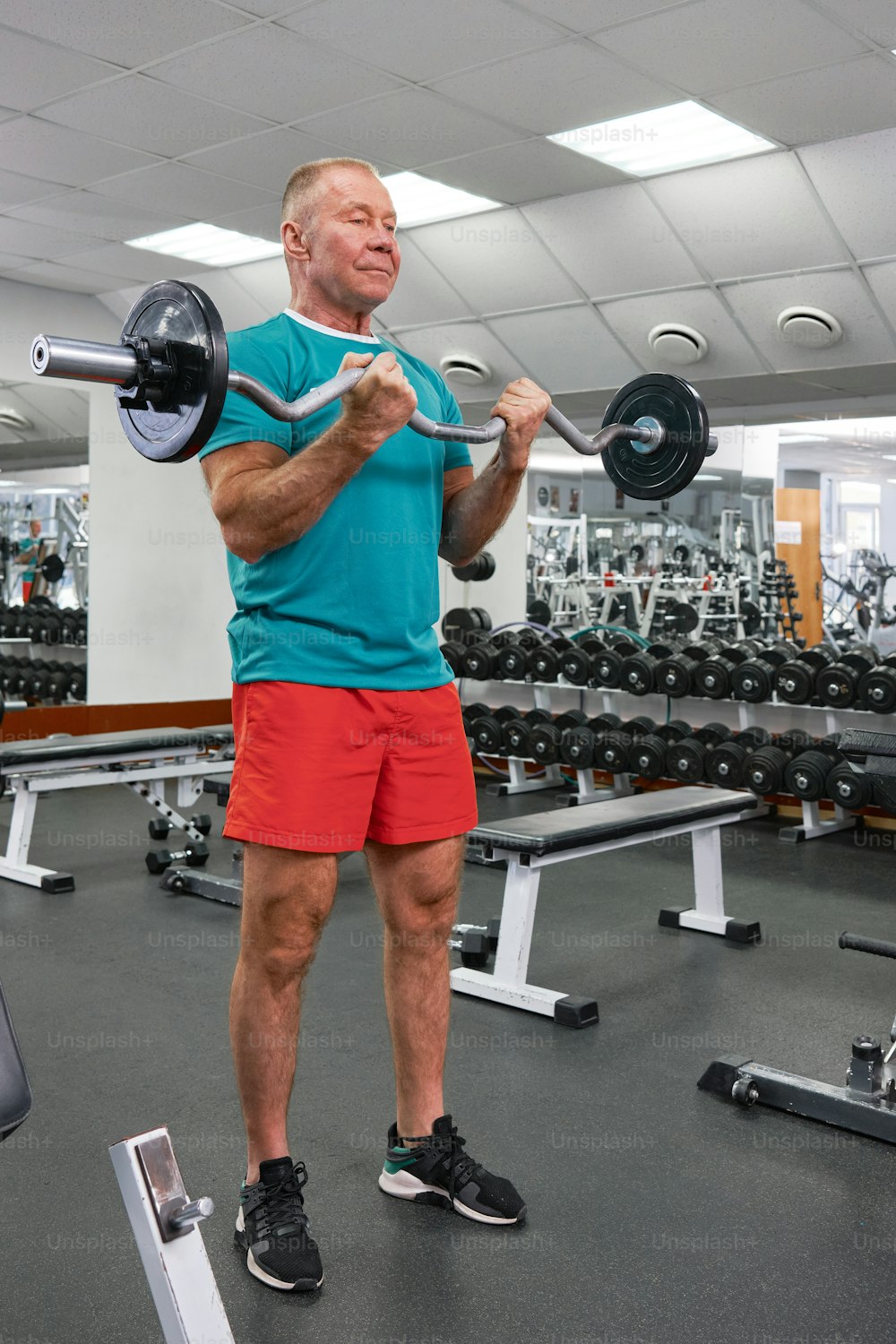 Ein Mann in einem Fitnessstudio hält eine Langhantel